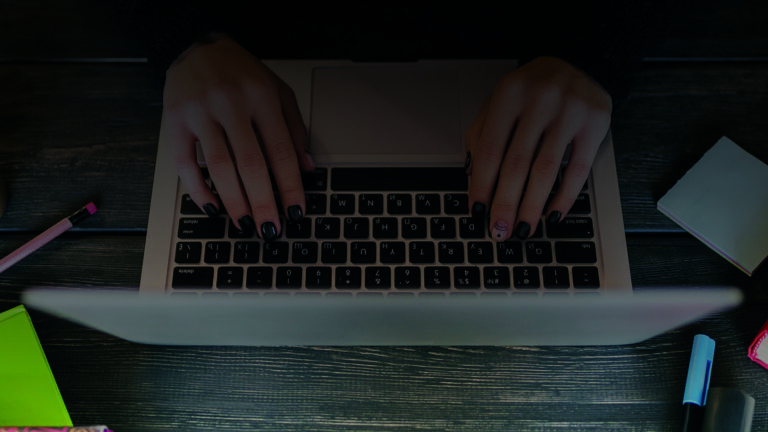 Hands typing on laptop keyboard