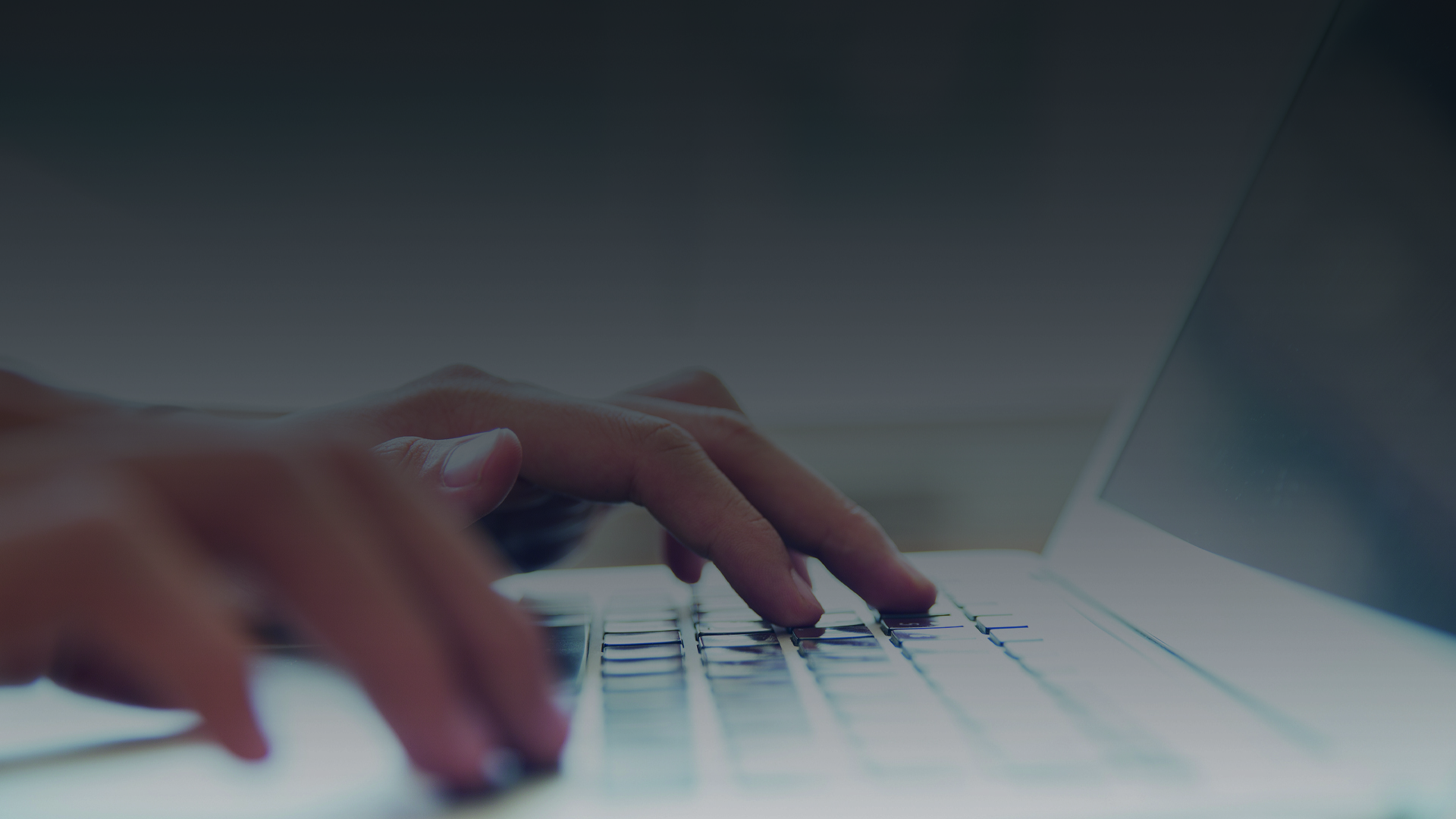 Hands typing on a laptop keyboard