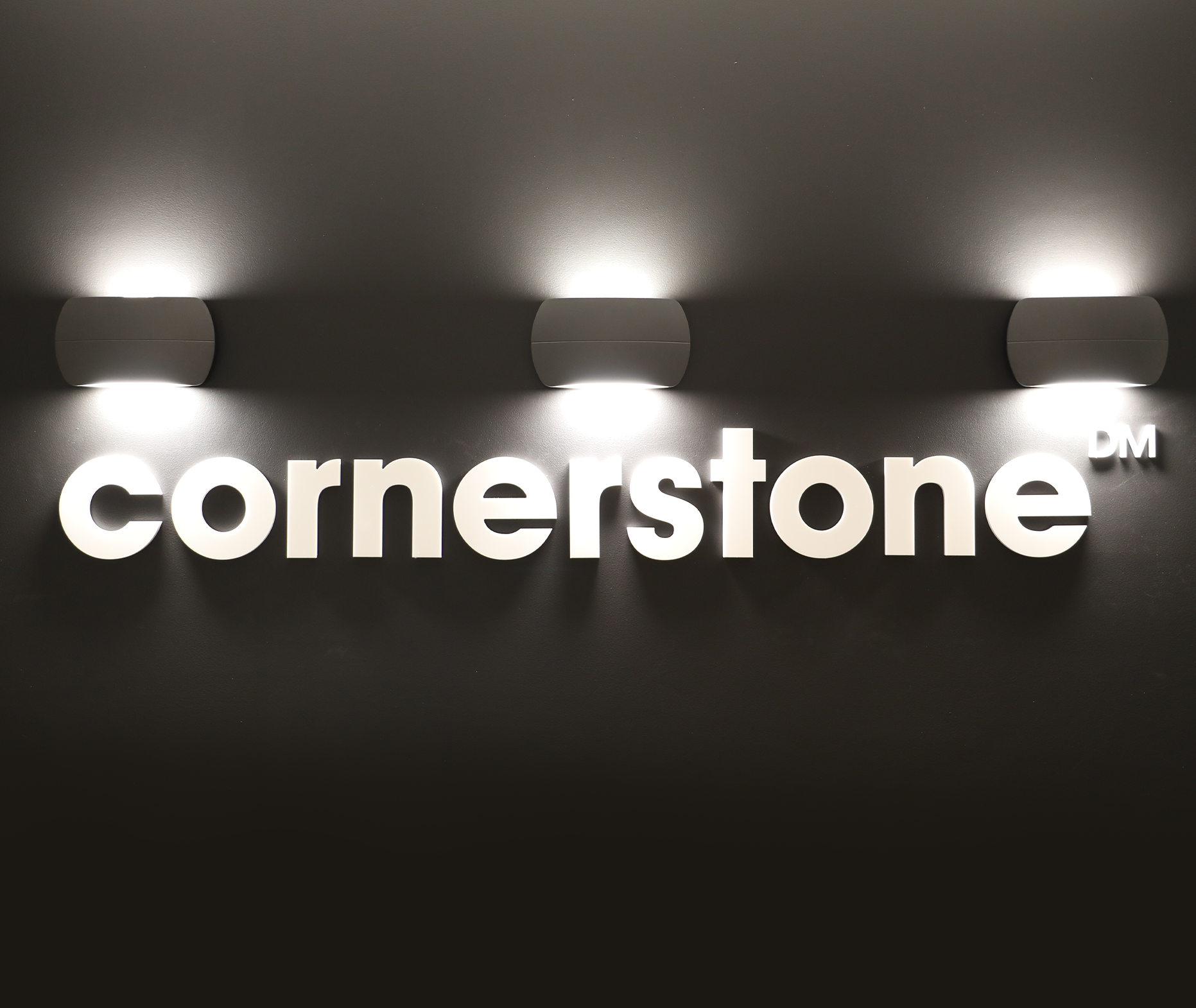 Interior signage of the Cornerstone logo lit up on a wall