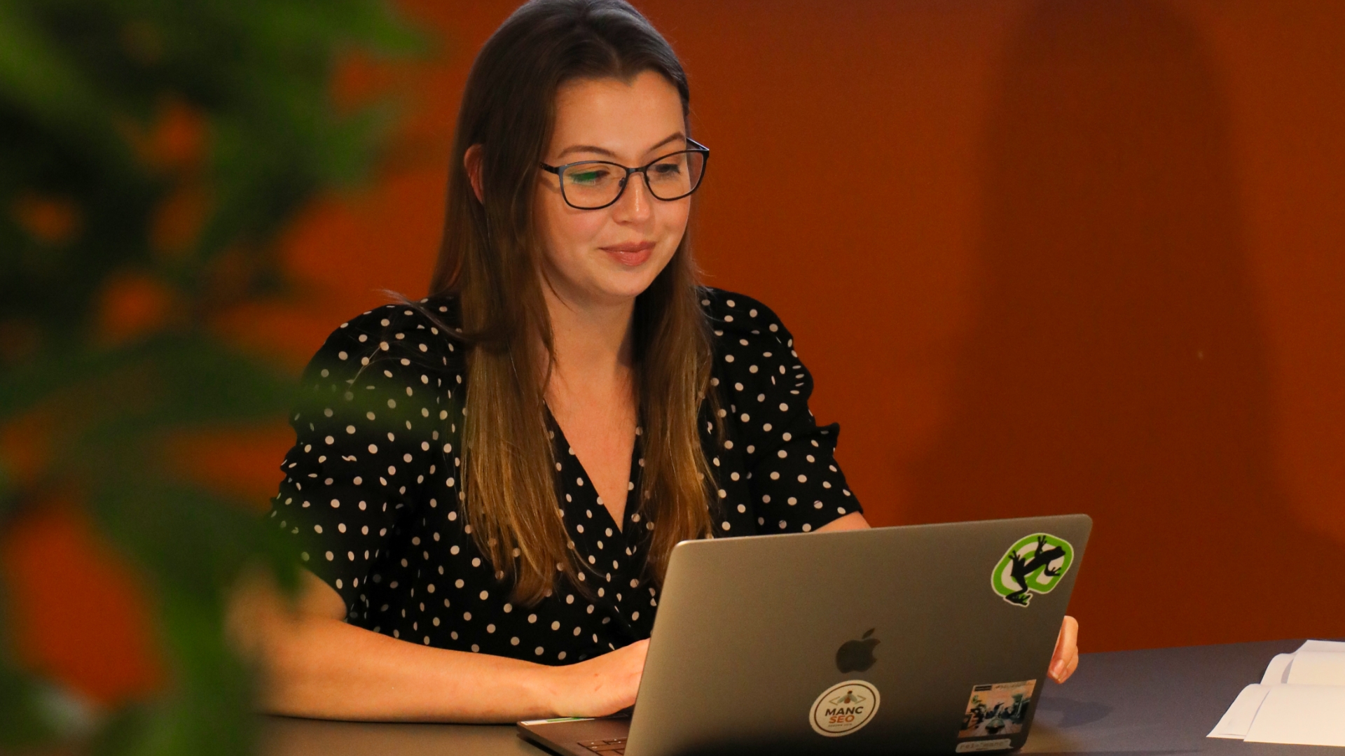 Jess working on her laptop in a meeting room