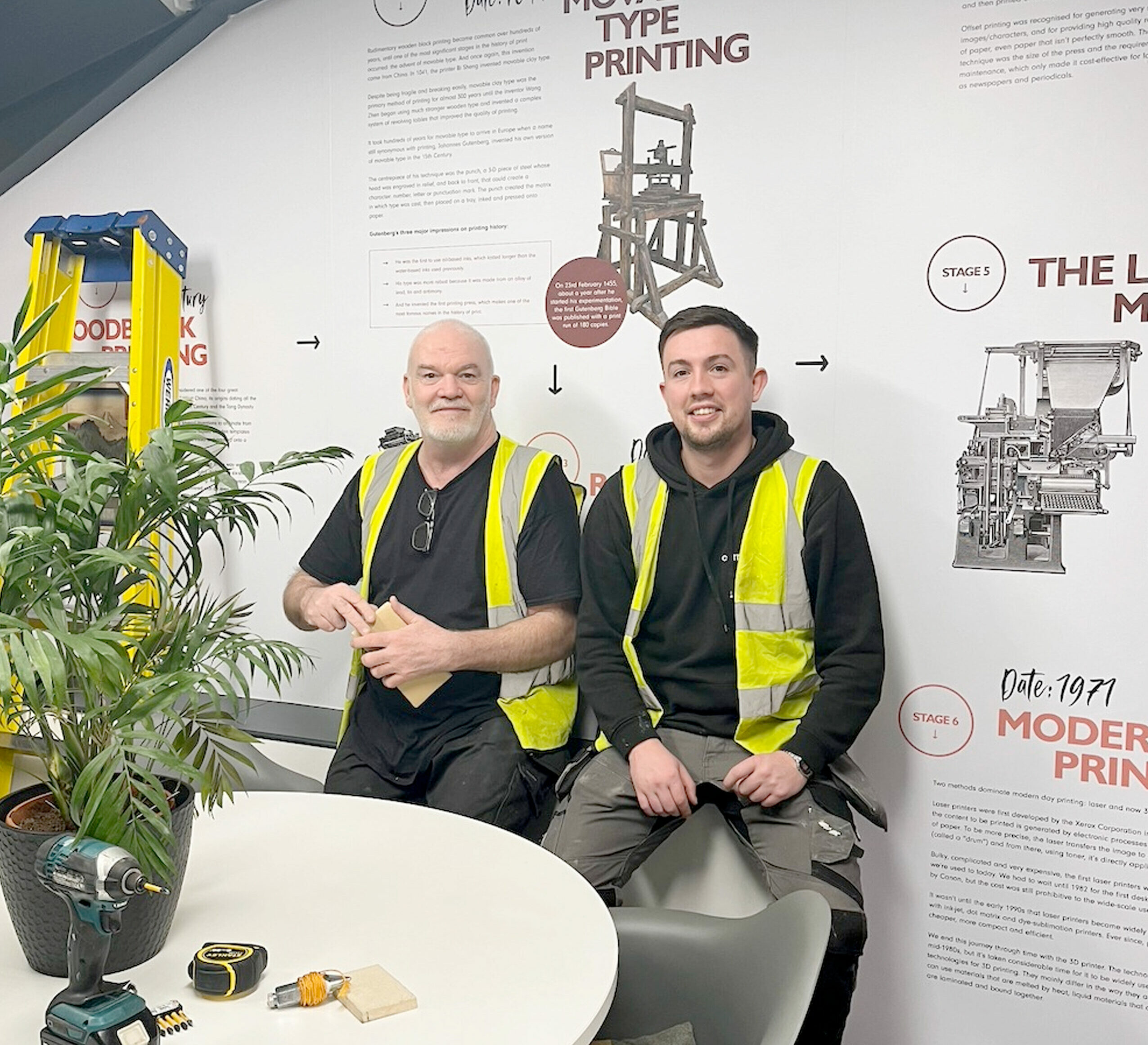 Sam and Steve fitting a large wall graphic at Cornerstone