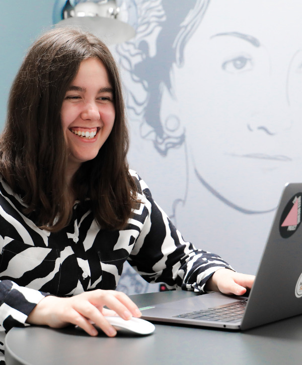 Apprentice team member at cornerstone - Madeline Thorp smiling whilst using her laptop